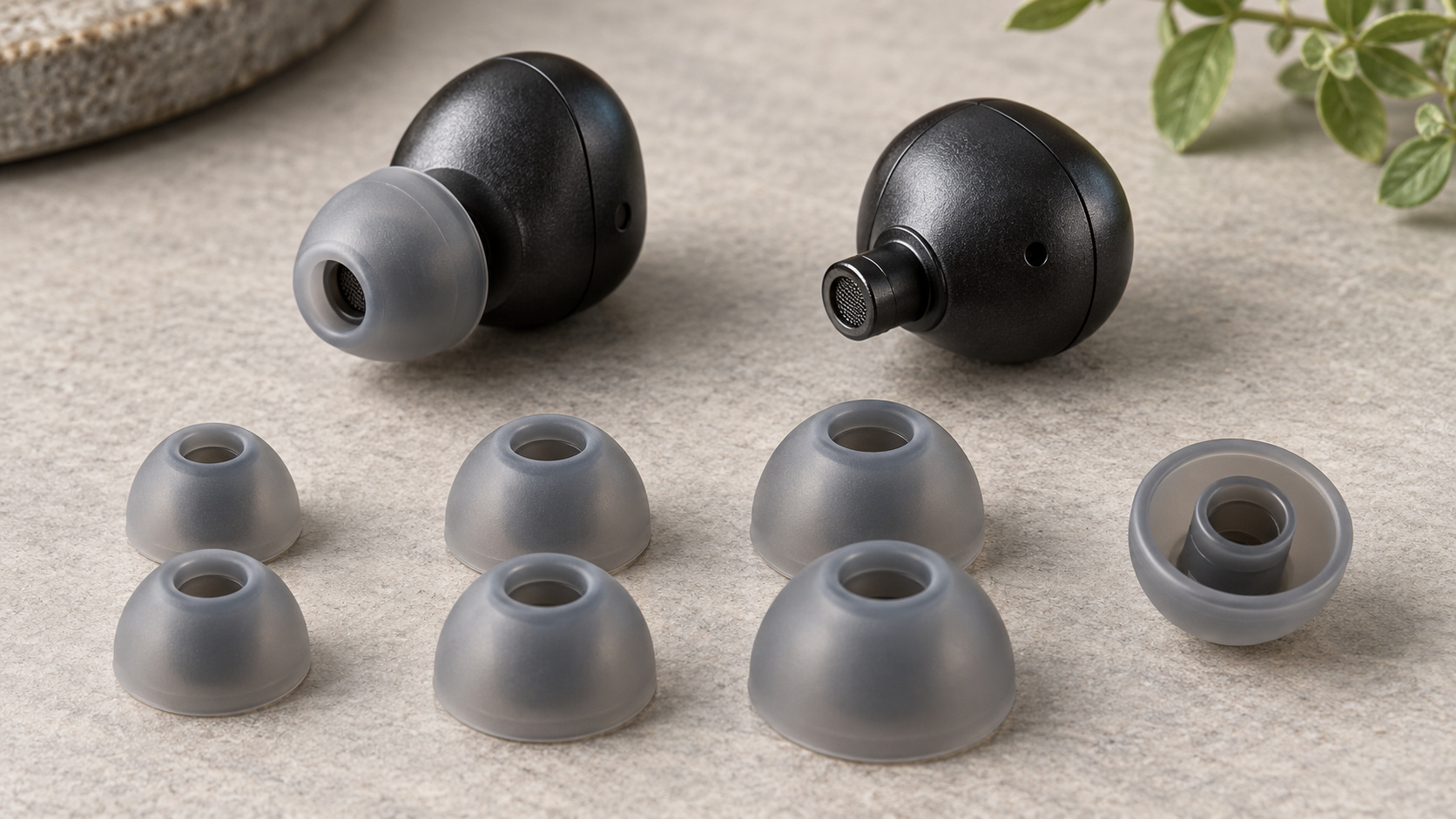 Bluetooth earbuds and separate silicone ear tips showing their skirts and attachment collars